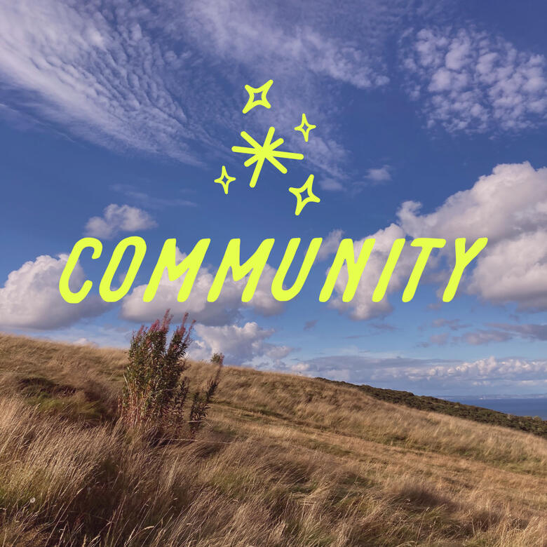 Wellness and Meditation community A bright blue sky punctuated with high-flying wisps of clouds floating over a grassy moor, the word "community" overlayed.
